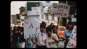 Several white people hold posters