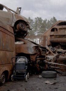 Two piles of rusty cars and a baby stroller