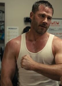 A sweaty man wearing a tank top.