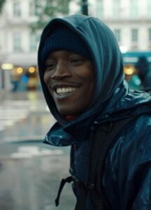 A Black man wearing a blue coat.