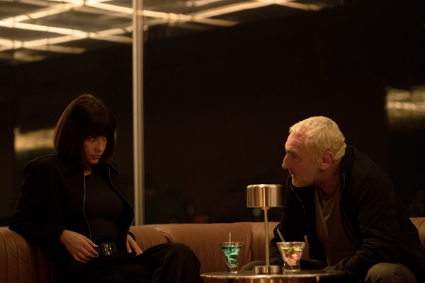 A woman and a man sit on a couch