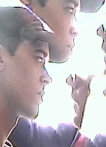 A blurry, kaleidoscopic image of two men looking to the camera's right