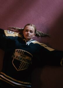 A young girl wears a hockey jersey