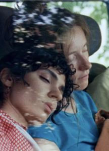 Two women lean on each other.